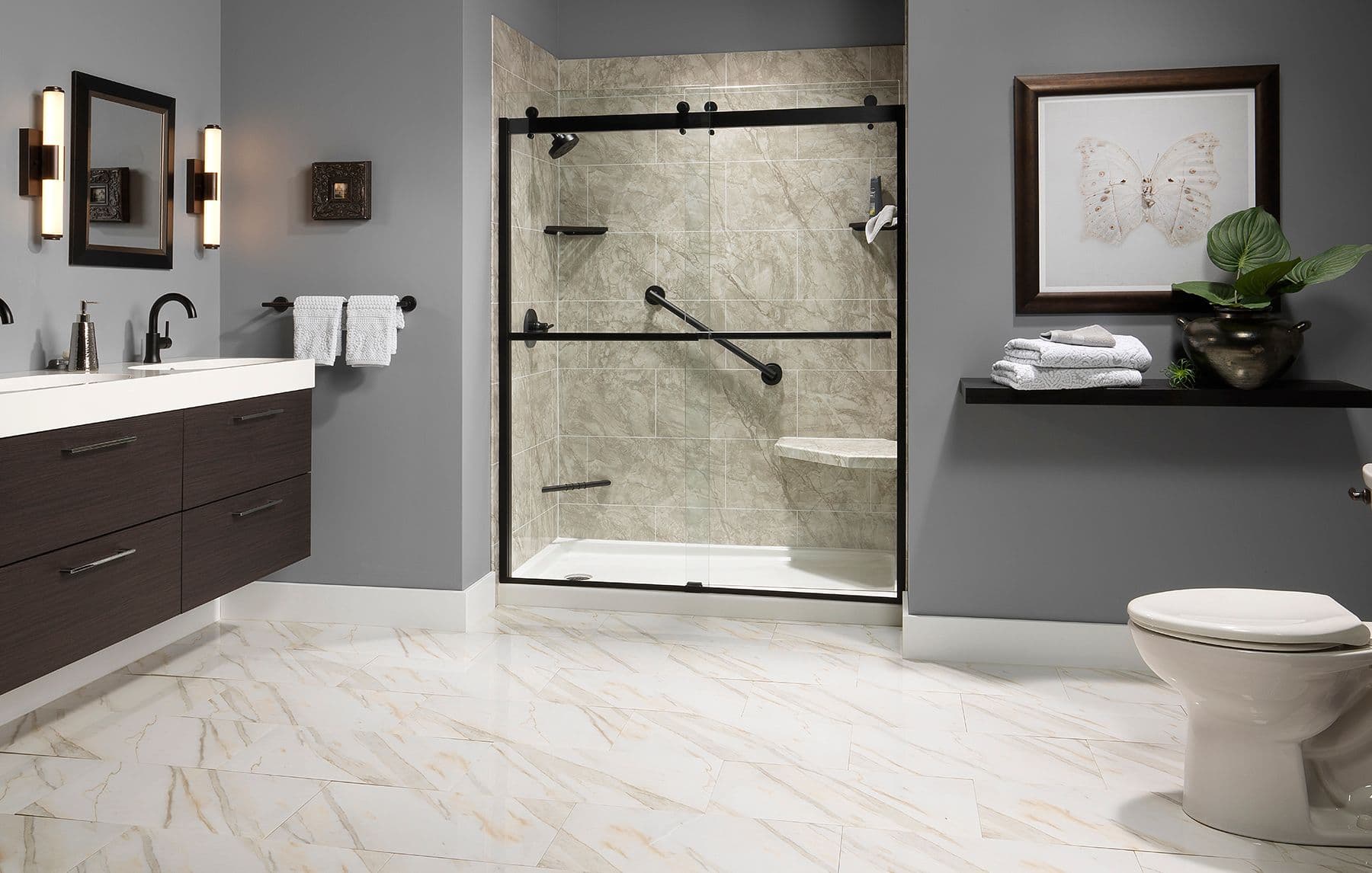 Modern bathroom with a glass-enclosed shower, marble floor, dark wood vanity, and elegant lighting. Towel rack and framed butterfly add decor.